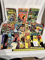 Photo showing lot of 18 vintage comic books from DC and Marvel with colorful covers typical of early 1970s style including War Worlds, Patchwork Man, All-Star Western, and others.