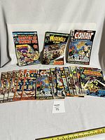 Top-level overview of all 18 comic books in the lot, showing front covers of Master of Kung Fu, Werewolf by Night, Conan le Barbare, and various others arranged on white fabric background.
