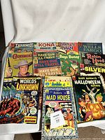 Photo showing the front covers of 12 vintage comic books from early 1970s with various characters and titles including Bugs Bunny, Archie, Worlds Unknown, Have Gun Will Travel and others.