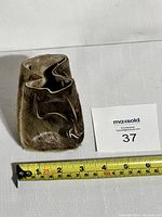 Front view of the fur pouch showing the drawstring closure and texture of the fur material, placed next to a measuring tape indicating about 5 inches in height.