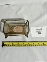 Top and side view of vintage brass and glass rectangular soap dish showing Victor Vaissier Paris floral label on base and brass ornamental feet