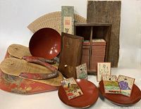 Photo showing the collection including dress zori slippers, red lacquer bowls, a box containing antique Japanese playing cards, and a folding fan.