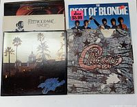 Six vintage classic rock vinyl records shown with original album covers: Electric Light Orchestra 'Discovery', Fleetwood Mac 'Rumours', The Eagles 'Hotel California', The Best of Blondie, Chicago self-titled album, and a partially visible album.
