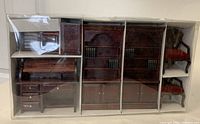 Vintage miniature doll house furniture set in original plastic packaging box with seven pieces including desks, bookcases with miniature books, and chairs.