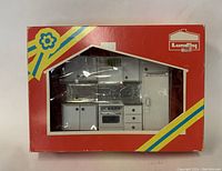 Photo of unopened vintage Lundby miniature kitchen set in original box with red background and Swedish flag-inspired stripes