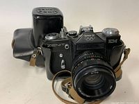 Side view of the black Zenit EM 35mm film camera with Helios-44M 58mm f/2 lens and attached leather strap.