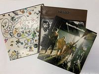 Photo showing three vintage classic rock LP records: Led Zeppelin III, The Band, and The Best of The Guess Who with visible cover art and condition.
