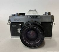Front view of Canon FTb 35mm film camera with attached Canon FD 35mm f/2 lens showing model name and lens details.