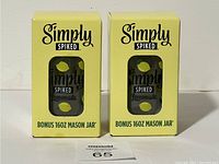 Two Simply Spiked branded 16oz mason jars in yellow boxes with lemon pattern and window showing the jar.