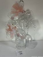 Group shot of Bohhmia crystal decanter and six glasses decorated with pink bows.