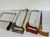 Four hand saws laid out horizontally showing different styles and handles.
