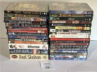 Front stacked view of 32 DVDs showing titles and DVD cases in shrink wrap.