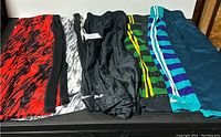 Photo showing all five pairs of Nike men's shorts arranged side by side, displayed to highlight designs and condition