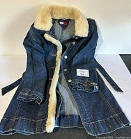 Front and interior of long denim jacket showing faux fur collar, button closures, and denim belt.