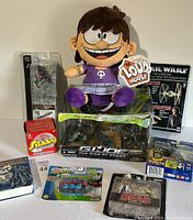 Wide view showing the complete toy lot including G.I. Joe set, The Loud House plush, Star Wars model, and various smaller toys.