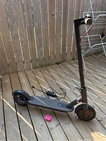 Full view of scooter and charger on wooden deck