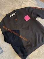 Black Off-White crewneck sweater with orange gothic text 'Every Living Creative Dies Alone' and small orange 'OFF' on chest, size XS.