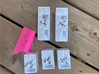 Five Wemo smart plugs arranged on a wooden surface showing plug prongs and labels