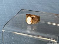 Angled front view showing the shell cameo and band texture.