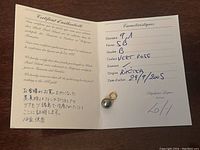 Certificate of Authenticity for the black pearl pendant, indicating pearl features and gold quality, with handwritten entries and a Japanese statement.