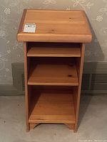 Front view of vintage pine end table showing flat top surface, three open shelves, and light brown wood grain.