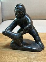 Front-right three-quarter view showing figure and seal on base