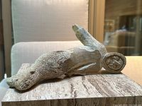 Side profile view of entire sculpture on travertine surface