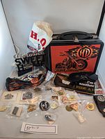 Full lot view showing lunch box, sunglasses, pins, patches, dog collar, and miscellaneous items spread on white background.