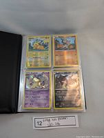 Photo of mini binder open showing four holographic Pokemon cards: Pikachu, Aegislash, Yveltal, and another.