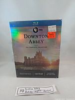 Front view of the sealed Downton Abbey Blu-Ray complete collection box with promotional stickers and sunset estate image.