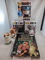 Overview of the three Funko Pop figures in boxes (R2-D2 #639, Princess Leia #607, Darth Vader #556) and light-up Chewbacca and Porg figurines with 'Dark Forces' official player's guide book