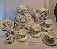 Complete set arranged front view with plates, bowls, cups and serveware