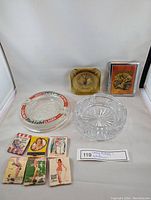 Overview of all ashtrays and matchbooks arranged on white background showing variety of styles and colors.