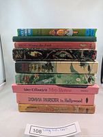 Stack of 9 vintage books showing titles and colorful spines.