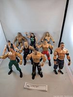 Nine Jakks Pacific wrestling action figures of different wrestlers displayed standing on white background