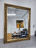 Full front view of the vintage Italian gold gilt rectangular wall mirror reflecting workshop items and painting.