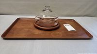 Rectangular teak tray with glass dome cheese dish centered on it, showing wood grain and overall condition.
