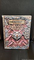 Front cover of Dungeons & Dragons Monster Manual showing detailed fantasy artwork and title.