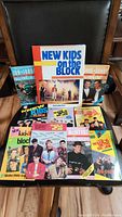 Photo of all 11 books laid out on a chair showing a variety of covers featuring New Kids on the Block members.