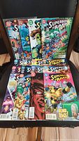 Photo showing all 16 Superboy comic books fanned out on a chair including issues 1 to 14 and 16 to 17.