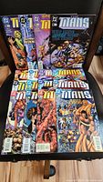 Lot of 16 Titans comic books laid out in two rows, showing colorful covers with various hero and action scenes. Issues are in good condition with no visible damage.