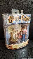 Front view of sealed packaged Harry Potter Magical Mini Collection figure with Harry and Hedwig in cage visible.