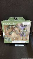 Front view of sealed Halo Master Chief vs Flood action figure set in green-themed packaging showing both figures.