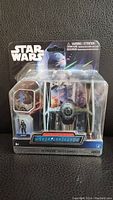 Front of sealed Star Wars Micro Machines Squadron TIE Fighter packaging with figure inside.