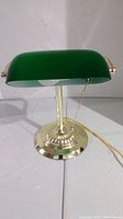 Front view of the green shade accountant desk lamp on brass base showing green rectangular glass shade, brass fittings, and round brass base with pull chain visible.