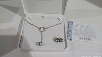 Pearl necklace and earrings inside Na Hoku box with care instructions card