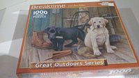 The puzzle box front showing artwork of two puppies on a porch with boots and outdoor equipment, with text 'Breaktime', 1000 Piece Puzzle, Great Outdoors Series, White Mountain Puzzles.