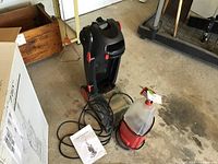 Cirrus carpet cleaner with detachable round spot cleaner, power cord, and manual on garage floor.