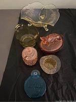 Full lot of six colored glass items shown together on black background.