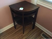 Side angle view of the dark wood telephone table showing its shape, legs, and pull-out feature.